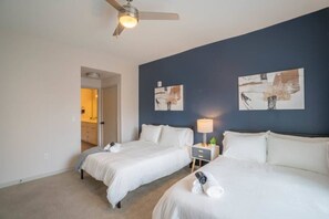 A hotel room with two beds, a ceiling fan, artwork on the wall, and a nightstand with a lamp. - Downtown Phoenix Retreat | Walk to Arts District (Phoenix)