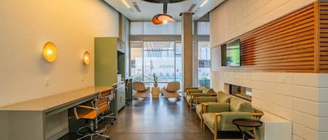 A modern office space with a reception area, seating, and a large window offering a view.