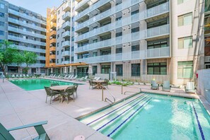 A modern apartment building with a swimming pool, outdoor seating, and a well-maintained garden area. - Central Downtown PHX | Pool, Gym, Parking, Balcony (Phoenix)
