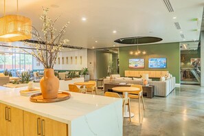 A modern hotel lobby with a reception desk, seating area, and a television screen. - DT PHX Condo with Pool Gym Parking WD (Phoenix)