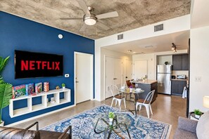 Un salon moderne doté d’un téléviseur à écran plat, d’une table basse et d’un espace détente.