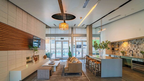 Een moderne lobby met een zithoek, een bar en een keuken.