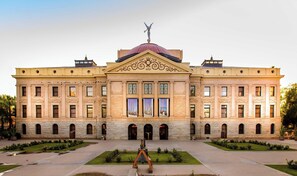 Un grand bâtiment historique doté d’un dôme central et d’une façade symétrique.