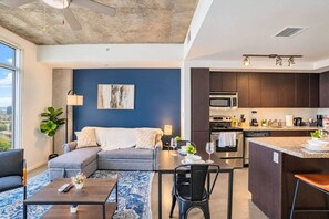 A modern living space with a sofa, coffee table, and dining area.