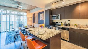 A modern kitchen with granite countertops, stainless steel appliances, and dark wooden cabinets. - Unwind near PHX DT Gym Balcony Pool Parking WD (Phoenix)