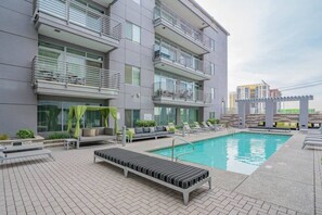 A modern building with a rooftop pool, outdoor seating, and a view of other buildings. - DT Phoenix | Pool, Gym, Parking, W/D Near Airport (Phoenix)
