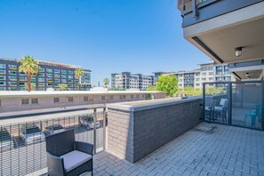 Une terrasse sur le toit, avec des espaces de détente en plein air, un bar et une vue sur les bâtiments environnants.