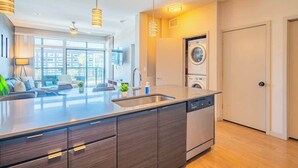 A modern kitchen with a central island, built-in dishwasher, and a washing machine.