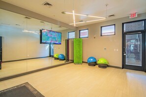 A gym with exercise balls, a TV, and a mirror. - Near PHX Airport Balcony,WD,Pool,Gym & Parking (Phoenix)