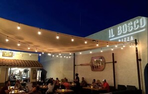 An outdoor dining area with string lights, tables, and chairs.