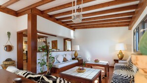 A spacious living room with a wooden ceiling, a sofa, a coffee table, and a zebra-patterned rug. - Boutique Boho Glam Villa With Private Pool (Yaiza)