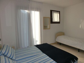Cozy retreat with a single bed, bedside table, and mirror.