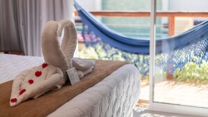 A neatly made bed with a white comforter and a towel folded in a heart shape with red heart decorations. - Uri Pousada (Maragogi)