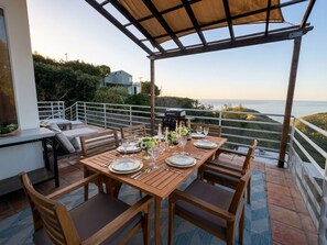 A wooden outdoor dining area with a view of the sea, a grill, and a covered seating area. - Malibu retreat, Panoramic views, Hot tub, Golf (Malibu)