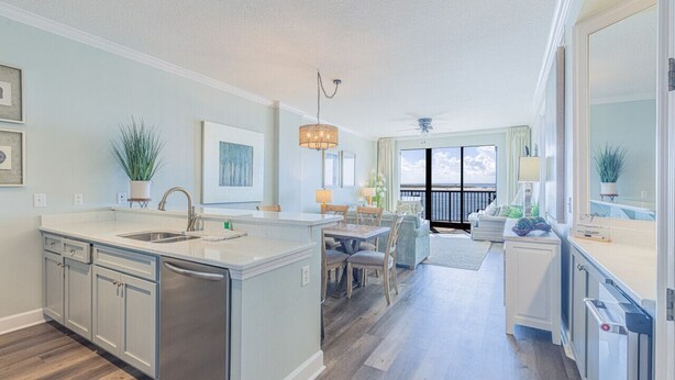 Une cuisine moderne dotée d’un îlot central, d’un coin repas offrant une vue agréable et d’un balcon avec une balustrade.
