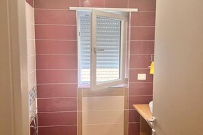 Een douche, een haardroger, een bidet, handdoeken