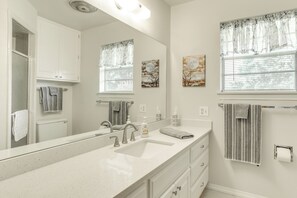 Bathroom features a large vanity, sink, mirror, towel racks, toilet, and shower area.