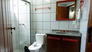 Une salle de bain équipée de toilettes, d’un lavabo, d’un miroir et d’une douche.