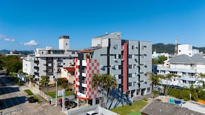 A multi-story hotel with a modern design, featuring balconies and a parking area. - Hanna Praia Hotel (Florianópolis)