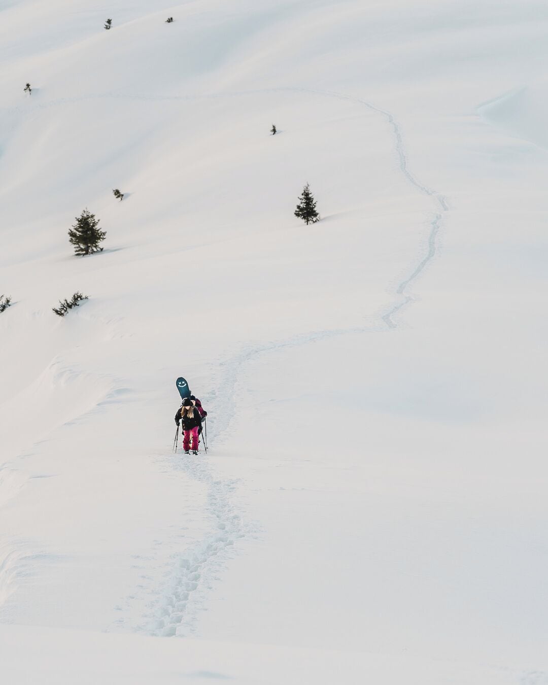 Un sendero nevado en la montaña con un solo esquiador.