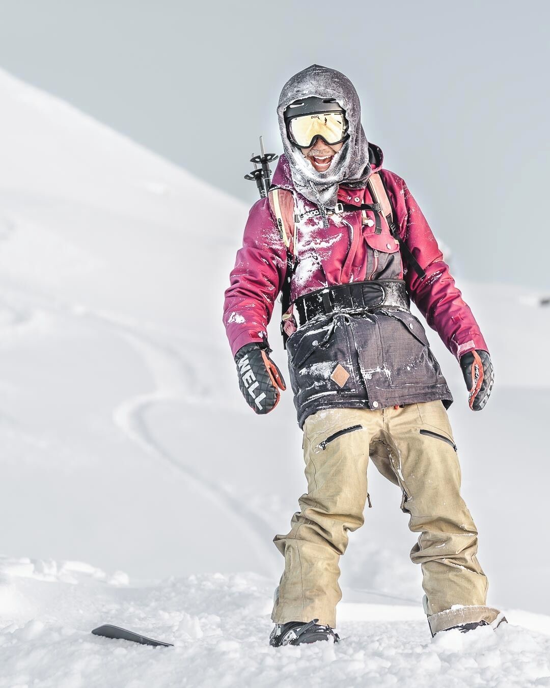 Una persona con ropa de abrigo parada sobre la nieve.