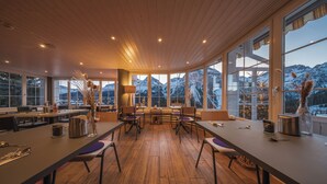Un comedor moderno con suelos de madera y ventanas amplias que ofrecen vistas a la montaña.