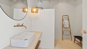 Une salle de bain moderne avec une baignoire sur pieds, un miroir, un porte-serviettes et une échelle en bois.