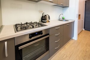 Estudio Deluxe | Cocina privada | Frigorífico grande, horno, placa de cocina y utensilios de cocina