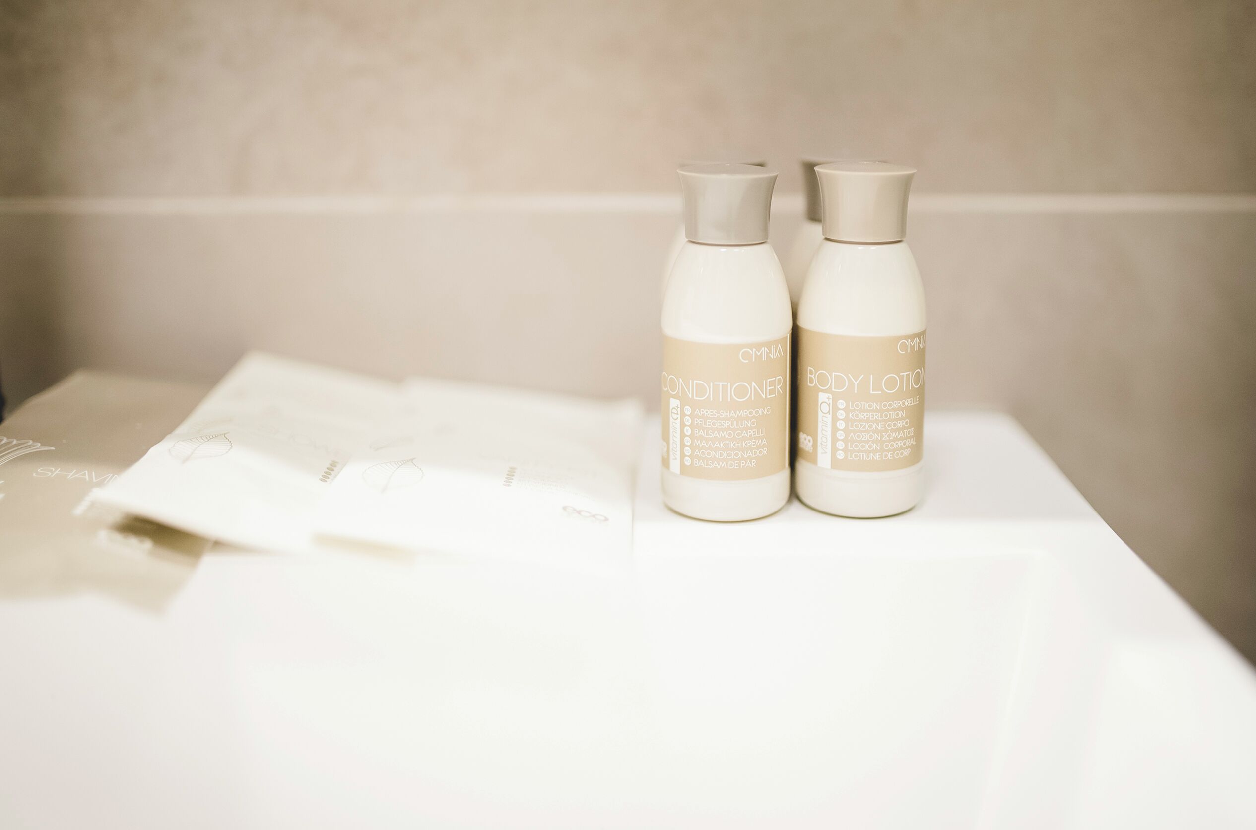 Two bottles of body lotion and conditioner on a white surface.