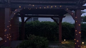 A covered outdoor area with string lights. - Modern Tiny Home Escape (Garfield Heights)