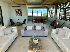 Relax in this inviting living room with a large sofa set and intimate seating area, perfect for socializing.