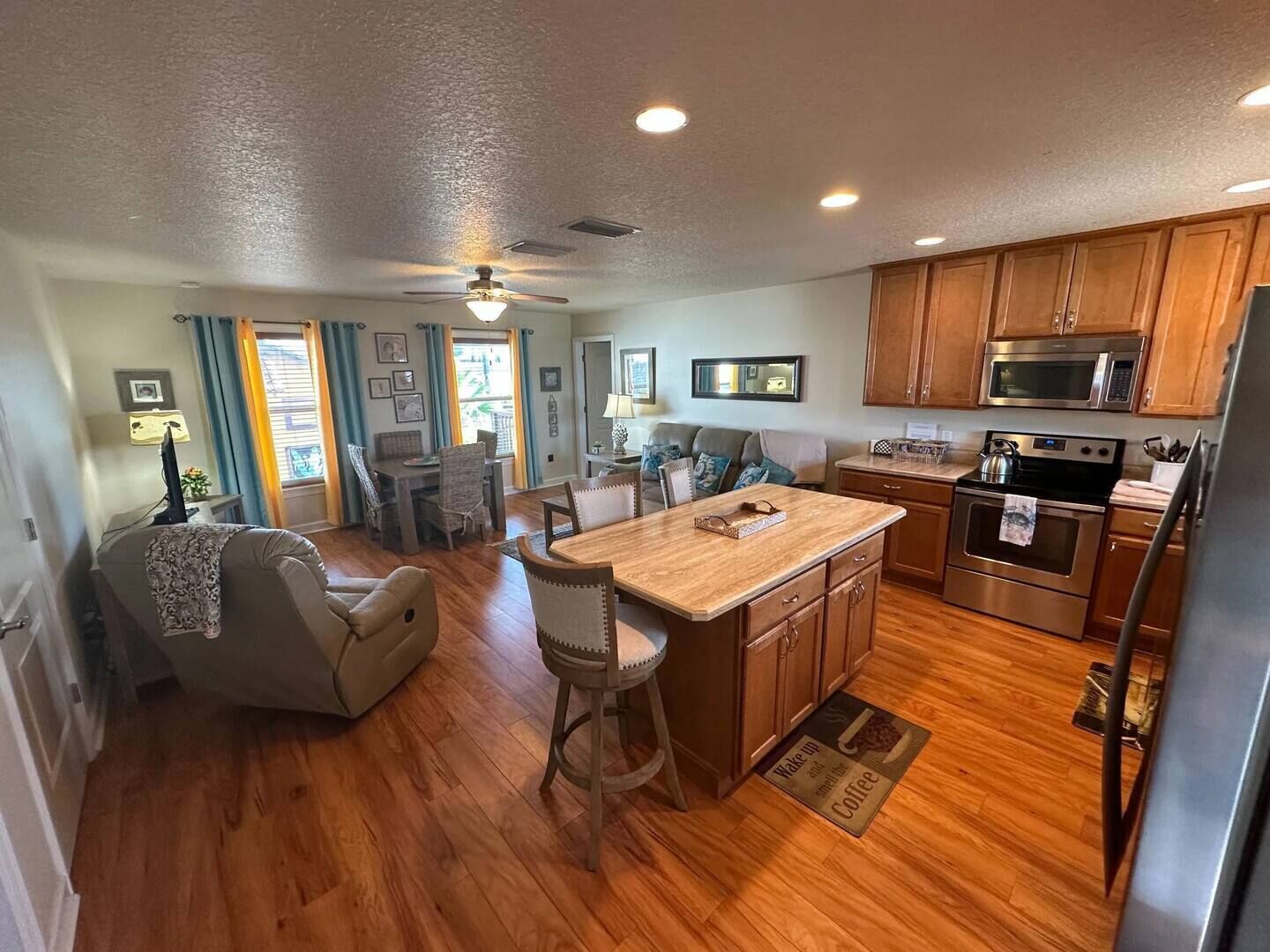 A spacious kitchen with wooden cabinets, a central island, and modern appliances.