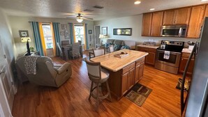A spacious kitchen with wooden cabinets, a central island, and modern appliances. - Unit Number 3 (New Smyrna Beach)