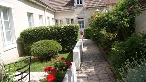 A stone pathway leading to a building with a tiled roof. - Hotel la Cognette (Issoudun)