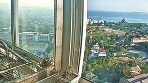 Un rascacielos con vistas a un paisaje urbano y una masa de agua.