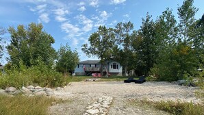 A gravel path leading to a house with a deck and outdoor seating.