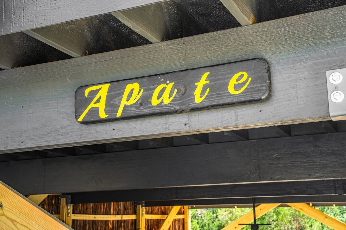 A sign with the word "Apate" in yellow letters on a metal surface.