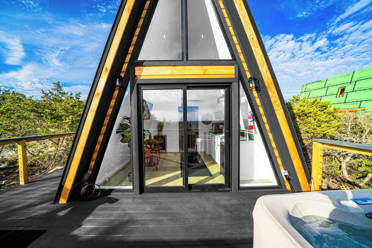 A modern house with a large glass door leading to a kitchen and dining area.