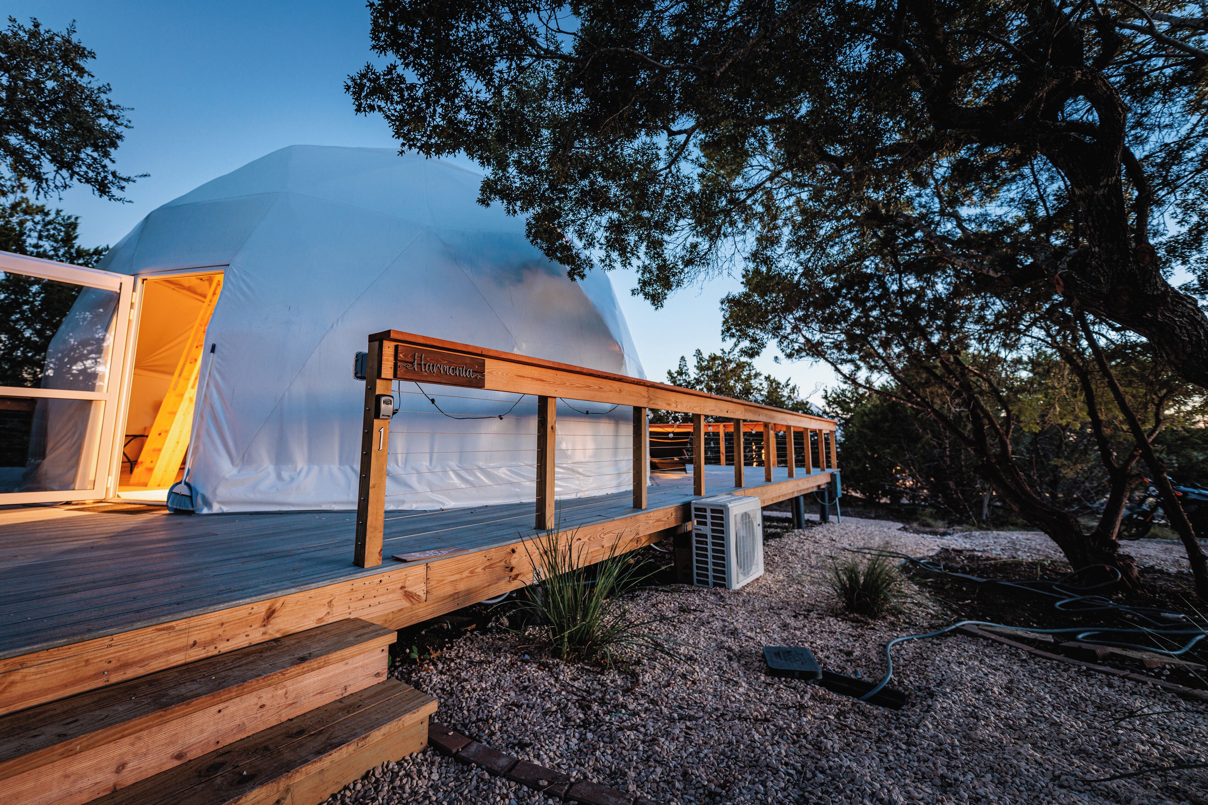 A modern, dome-shaped building with a wooden deck and a sign that reads "Harmony."