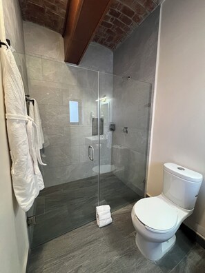 Suite estudio | Baño | Regadera, amenidades de baño ecológicas, secadora de cabello, batas