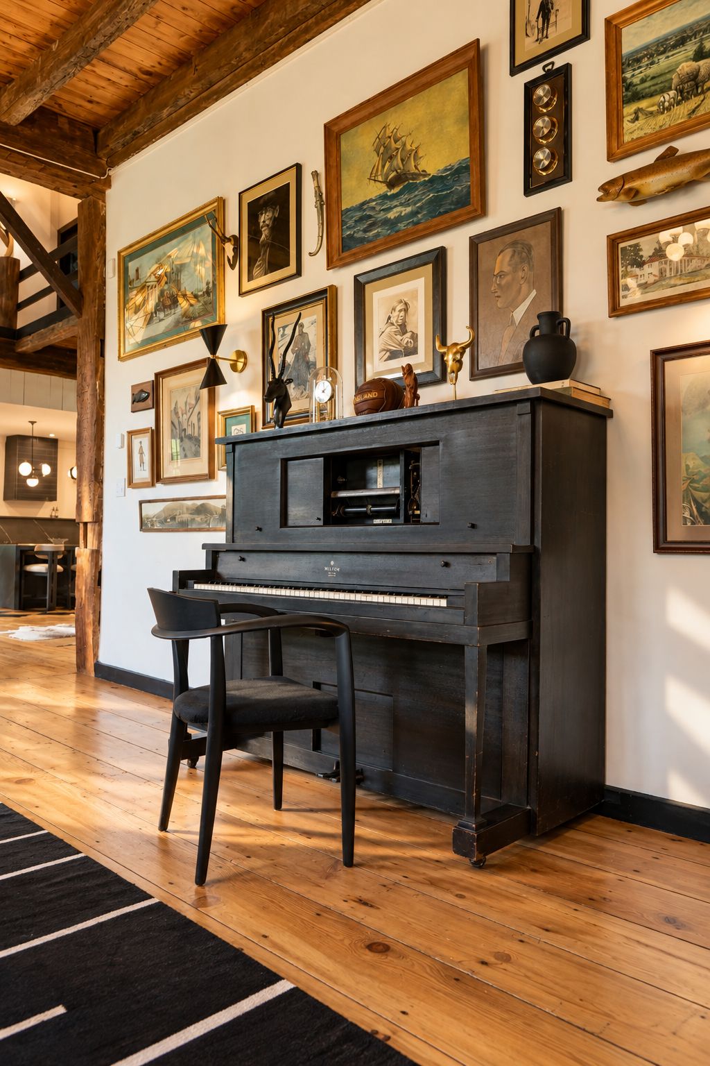 Una stanza con un pianoforte a coda, parquet e una parete decorata con opere d'arte incorniciate.