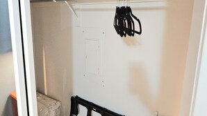 A closet with a hanging rod, folded towels, and a small black chair. - Lake life 1-bedroom,1-bath condo in peaceful Garland TX (Garland)