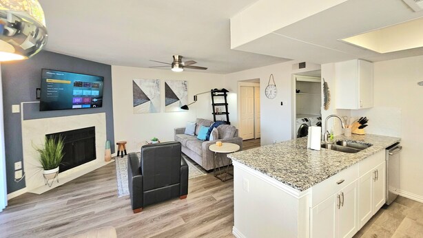 A modern kitchen with a granite countertop, white cabinets, and a built-in oven. - Lake life 1-bedroom,1-bath condo in peaceful Garland TX (Garland)