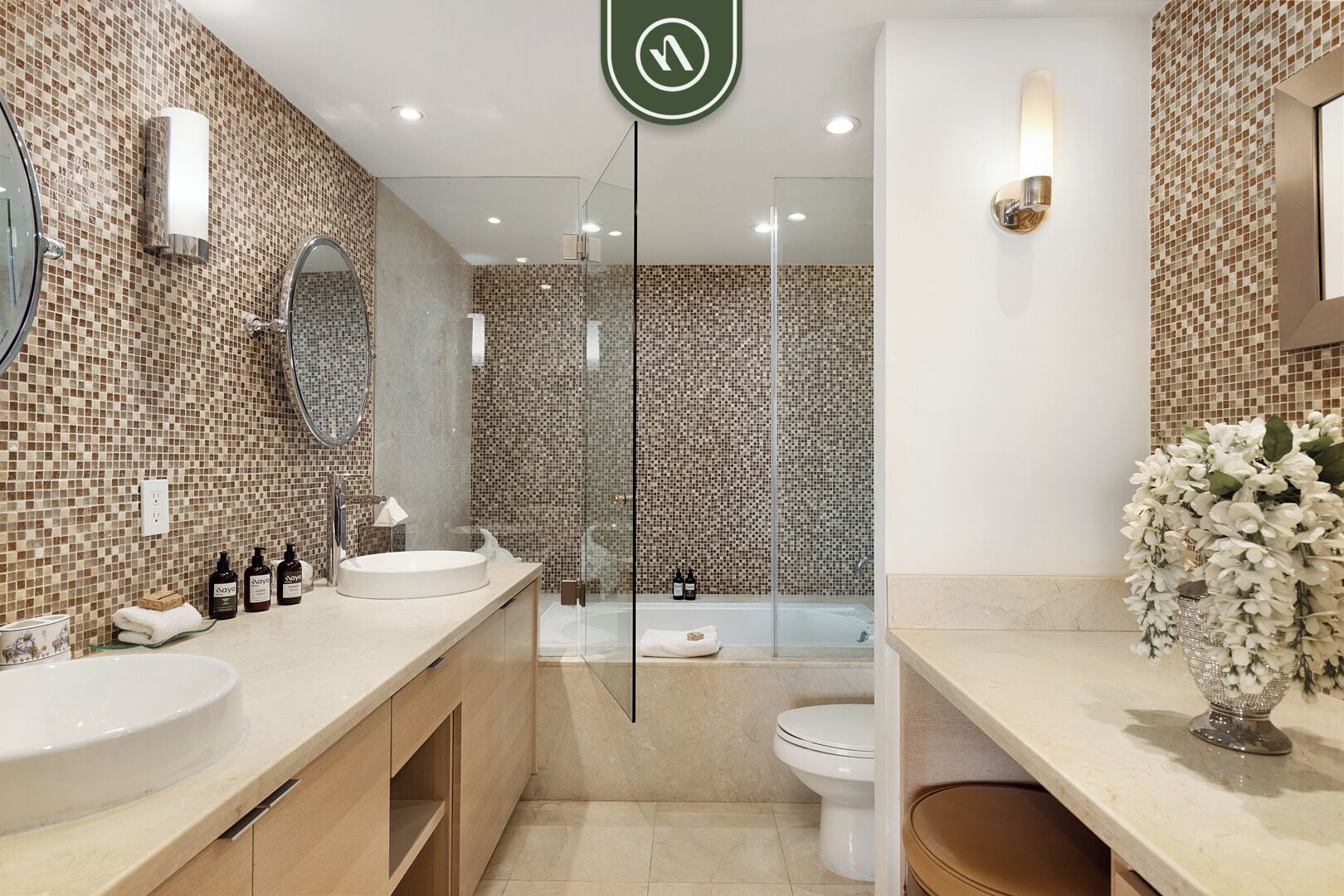 Un bagno moderno con due lavabi, cabina doccia in vetro e un water.