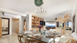 Un comedor moderno con una mesa de vidrio preparada para seis personas, rodeada de sillas de madera.