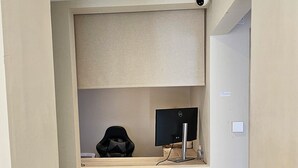A narrow hallway with a recessed ceiling, a security camera, and a monitor on a shelf. - MSM Arena Hotel (London)