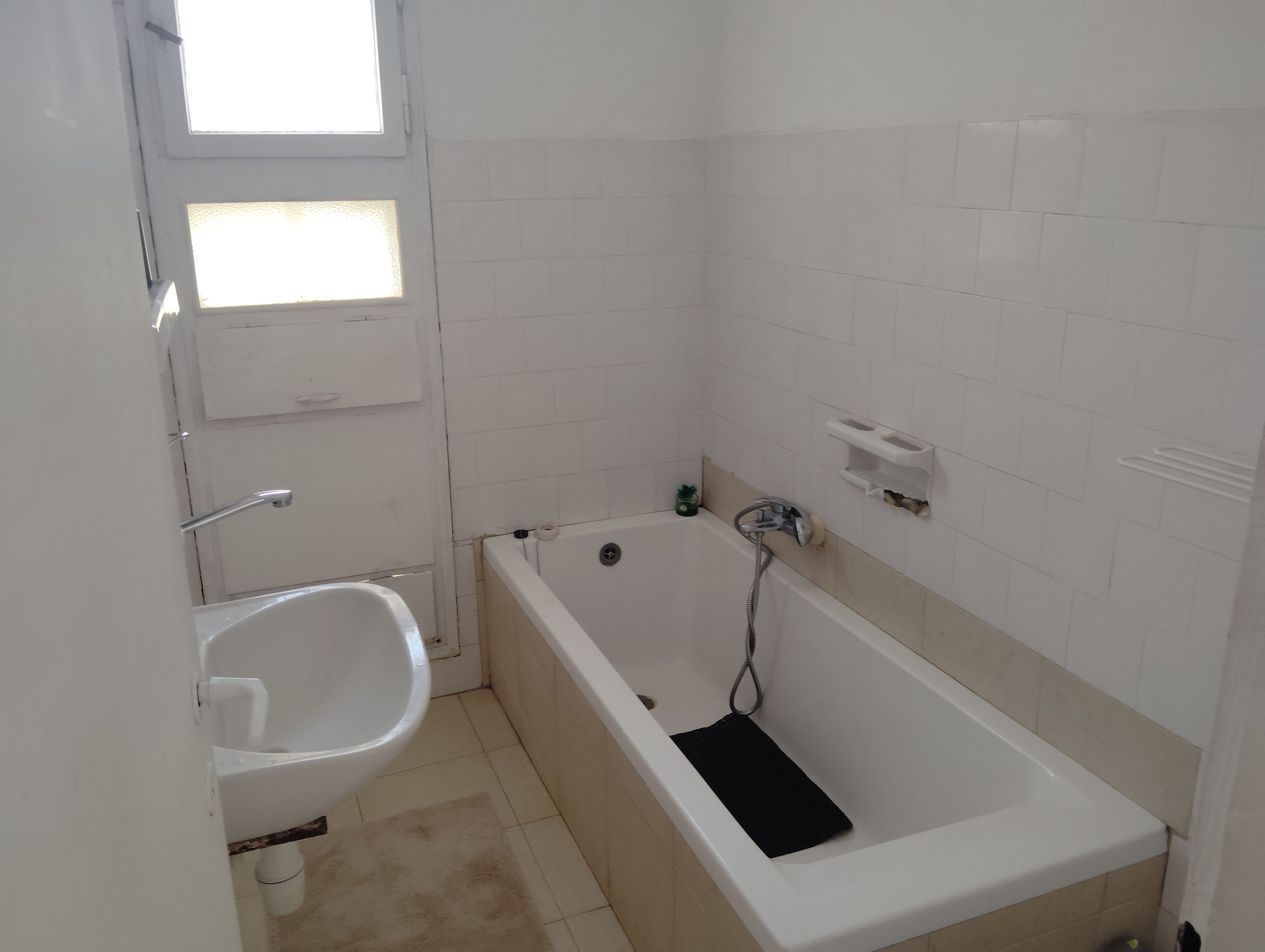 Et badeværelse med badekar, toilet og håndvask.