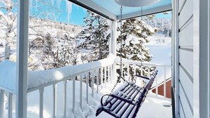 A snow-covered porch with a bench and a hanging light fixture. - Charming Cottage steps to restaurants, shops & slopes (Park City)
