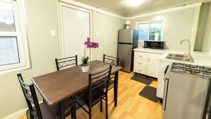 Une cuisine compacte comprenant une table à manger, des chaises, un réfrigérateur, un four à micro-ondes et une cuisinière.