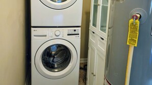 Une machine à laver et un sèche-linge superposés dans une buanderie.